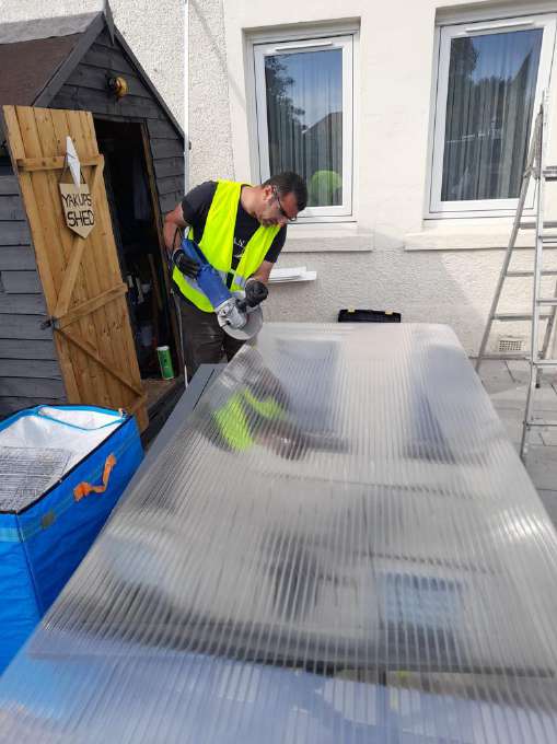 Handyman using a tile cutter in a garden
