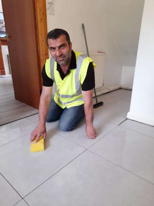 Handyman cleaning a freshly tiled floor